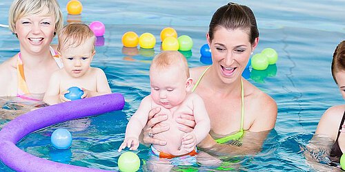 vier Frauen mit Babys im Wasser