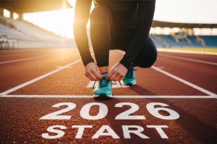 Mensch steht vor Startlinie und bindet seine Schuhe zu