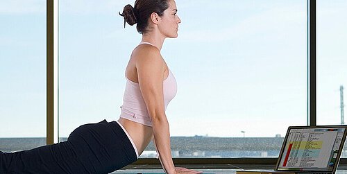 Frau macht Yoga mit Laptop