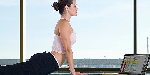 [Translate to Englisch:] Frau macht Yoga mit Laptop