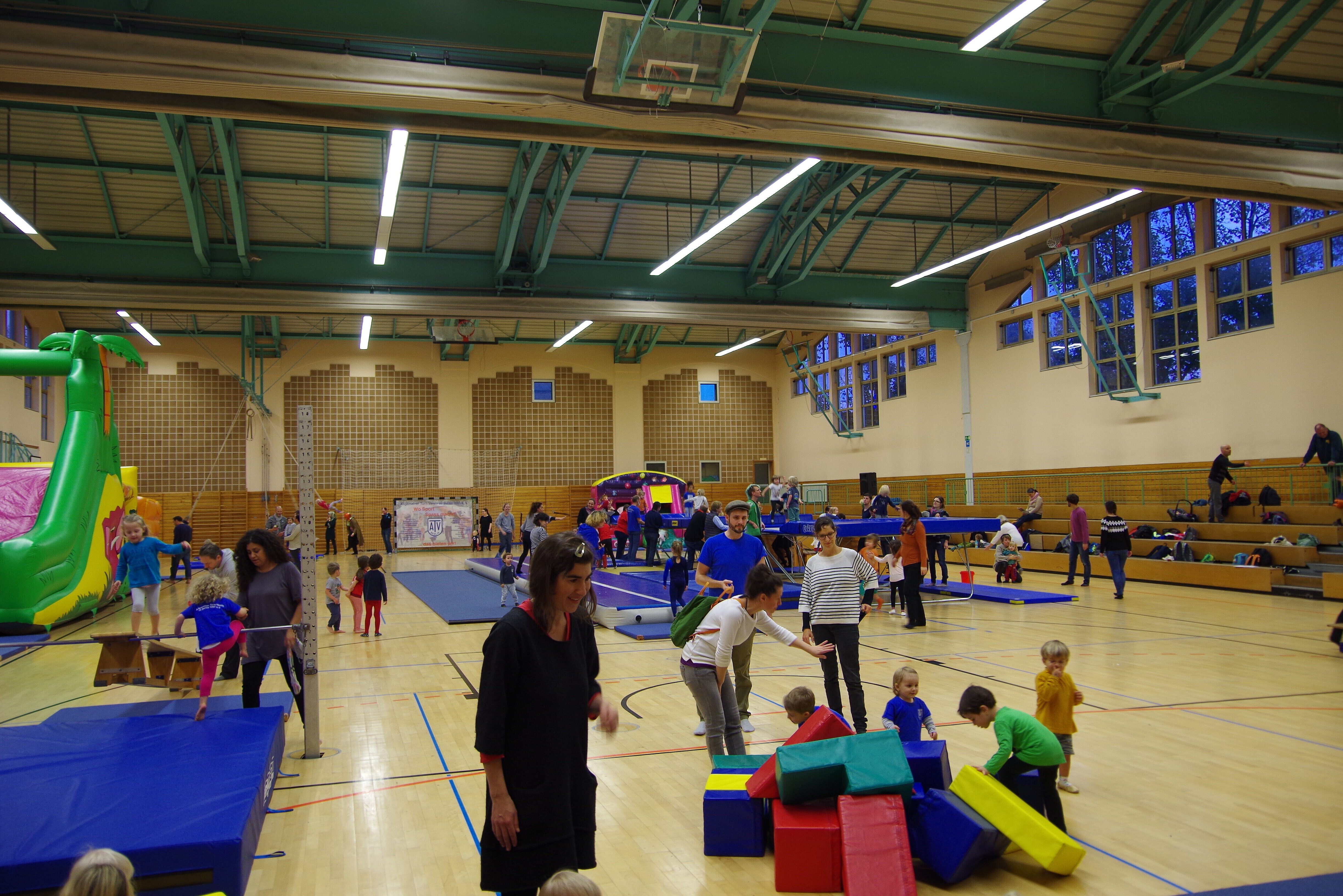 Turnhalle mit vielen Menschen und Geräten