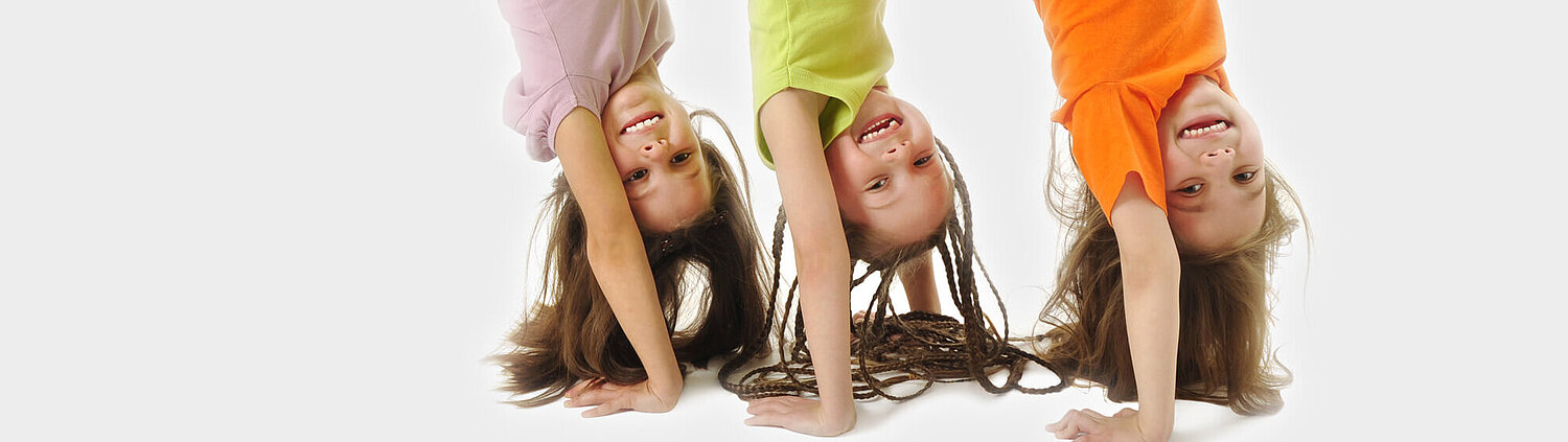 Foto von drei Kinder die ein Handstand amchen